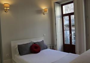 een slaapkamer met een bed met een rood kussen erop bij Oporto Coliseum Studio in Porto