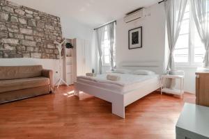 a bedroom with a bed and a brick wall at Apartments Artemus Music in Piran