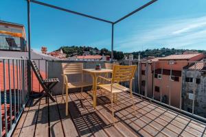 a balcony with a table and chairs on a roof at Apartments Artemus Music in Piran