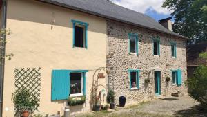 a stone house with blue shutters on it at Maison Mignaquy in Charritte-de-Bas