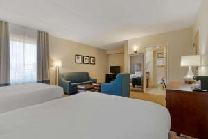 a hotel room with a bed and a living room at Comfort Inn Mechanicsburg - Harrisburg South in Mechanicsburg