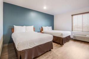 A bed or beds in a room at WoodSpring Suites Houston Baytown