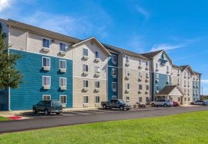 a large apartment building with cars parked in a parking lot at WoodSpring Suites Houston Baytown in Baytown