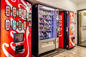 WoodSpring Suites Houston Baytown في باي تاون: آلة بيع كولا كوكا بجوار آلة بيع المشروبات الغازية