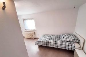 um pequeno quarto com uma cama e uma janela em Work & Stay Apartments mit Garten 