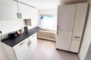 uma cozinha com um frigorífico branco e uma janela em Work & Stay Apartments mit Garten 
