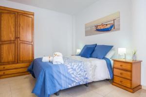Un dormitorio con una cama azul y blanca y un tocador en Apartamento Las Playitas, en Tuineje