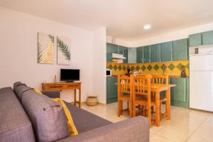 ein Wohnzimmer mit einem Sofa und einem Tisch sowie eine Küche in der Unterkunft Apartamento Las Playitas in Tuineje