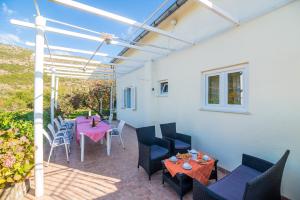 une terrasse avec une table et des chaises roses dans l'établissement Villa Desin, à Molunat