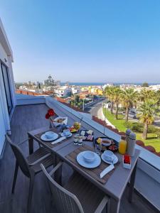 a table on a balcony with a view of the ocean at Agua Hotels Alvor Jardim in Alvor