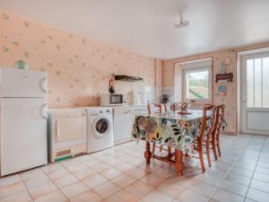 cocina con mesa y lavadora en Authentic Cottage in Nouart near Forest, en Nouart