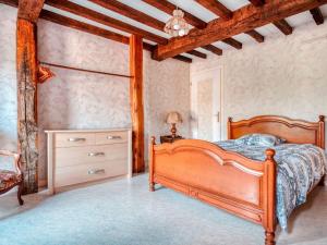 a bedroom with a wooden bed and a dresser at Authentic Cottage in Nouart near Forest in Nouart