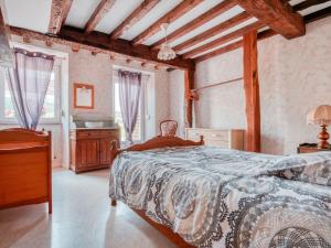 ein Schlafzimmer mit einem Bett in einem Zimmer mit Holzdecken in der Unterkunft Authentic Cottage in Nouart near Forest in Nouart