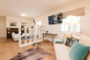 ein Wohnzimmer mit einem weißen Sofa und einem Tisch in der Unterkunft Villa Gelbmann - Ferienwohnungen Velden in Velden am Wörthersee