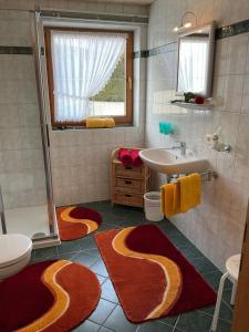 a bathroom with red and yellow rugs on the floor at Apart Christina in Tarrenz