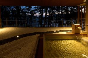 釜石にある浜べの料理宿 宝来館の家の上に噴水のあるスイミングプール