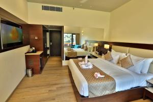 a hotel room with two beds and a flat screen tv at Seasons Park Resort in Udaipur