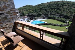 a balcony with two chairs and a view of a yard at Seasons Park Resort in Udaipur