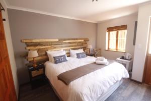 een slaapkamer met een groot bed met een houten hoofdeinde bij Eazy Sleep Accommodation in Swakopmund