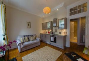 een woonkamer met een bank en een keuken bij ALTIDO Chic apt in the Royal Mile Tower in Edinburgh