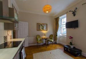 een keuken met een tafel en stoelen in een kamer bij ALTIDO Chic apt in the Royal Mile Tower in Edinburgh