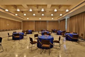 a banquet hall with blue tables and chairs at Seasons Park Resort in Udaipur +72 photos