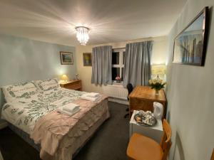 sypialnia z łóżkiem, biurkiem i oknem w obiekcie Prince Cottage w mieście Colchester