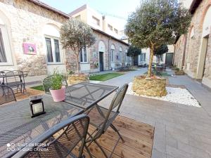 un patio con mesa, sillas y un árbol en Alloggi Palmini, en Florencia