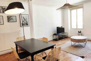 a dining room with a black table and chairs at Le stratégique - Hyper Centre Verdun in Verdun-sur-Meuse