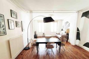 een woonkamer met een tafel en stoelen en een bank bij Le stratégique - Hyper Centre Verdun in Verdun-sur-Meuse