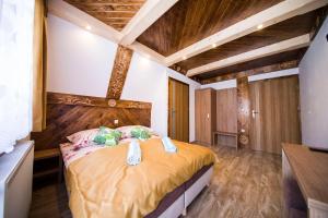 DW Maria 2 في زاكوباني: غرفة نوم بسرير في غرفة بسقوف خشبية