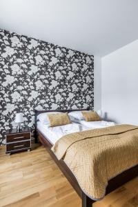 1 dormitorio con 1 cama con papel pintado en blanco y negro en Apartament Stara Polana Odkryj Zakopane, en Zakopane