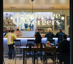 un groupe de personnes assises à une table dans un restaurant dans l'établissement Auberge des Vergers, à Genève