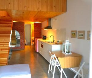 a kitchen with a sink and a counter with chairs at La Holandesa in Cercedilla