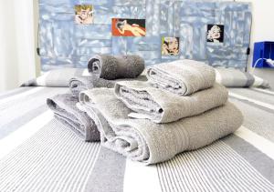 una pila de toallas sentadas encima de una cama en Sa Caletta Appartamenti, en Portoscuso