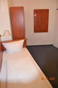 een kleine slaapkamer met een bed met een deur bij Hotel Zeil in Frankfurt am Main