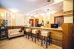 a woman standing at the counter of a salon at Natur Hotel Kövestető in Hosszúhétény