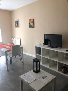 a living room with a table and a tv and a table and chairs at Damas 3 in Cáceres