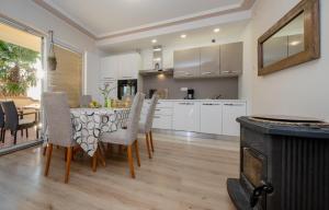 cocina y comedor con mesa y sillas en Apartments Vladimir 2836 en Rab