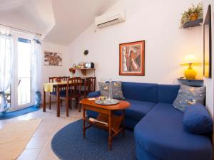 - un salon avec un canapé bleu et une table dans l'établissement Apartments Grivičić, à Krapanj
