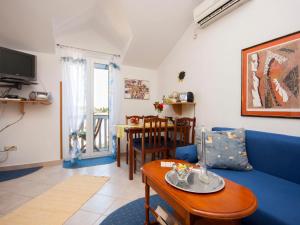 a living room with a blue couch and a table at Apartments Grivičić in Krapanj