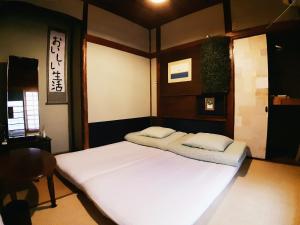 a bed in a room with two pillows on it at Guest House FUTARENO in Yokohama