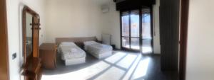 a room with two beds in a room with a window at NEW FAMILY INN in Pero
