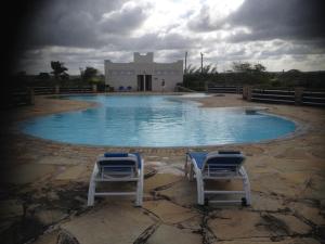 two chairs sitting in the middle of a swimming pool at Romantic Beach House Vipingo in Vipingo
