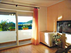a living room with a large window with a view at Apartments Josip 2830 in Rab