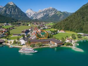 an aerial view of a resort with a cruise ship in the water at Hotel Christina - Ihr kleinstes 4* Hotel am Achensee in Pertisau