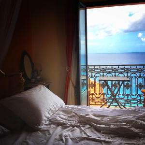 ein Schlafzimmer mit Bett und Blick auf das Meer in der Unterkunft Casa Angelieri in Pizzo
