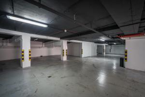 an empty parking garage with white and yellow columns at HOLM Boutique & SPA - IK Collection in St. Julianʼs
