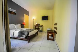- une chambre avec un lit et une table dans l'établissement Ganalé Hôtel, à Dakar