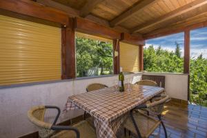 einen Tisch mit Stühlen und eine Flasche Wein auf der Veranda in der Unterkunft Apartment Vili in Pinezici + 24 Fotos